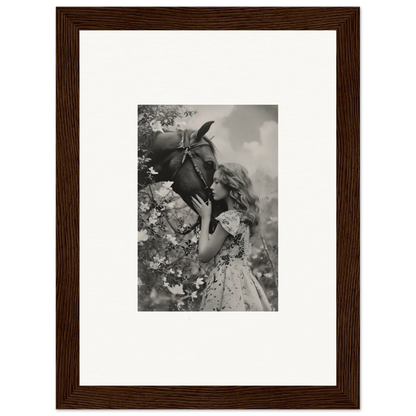 Framed black and white photo of a girl smelling a flower, perfect for room decoration