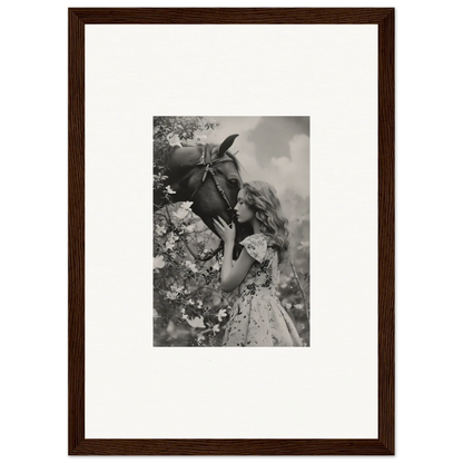 Framed black and white photo of girl smelling flower, perfect for room decoration