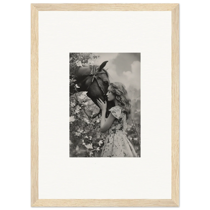 Framed black and white photo of a girl smelling a flower, perfect for room decoration