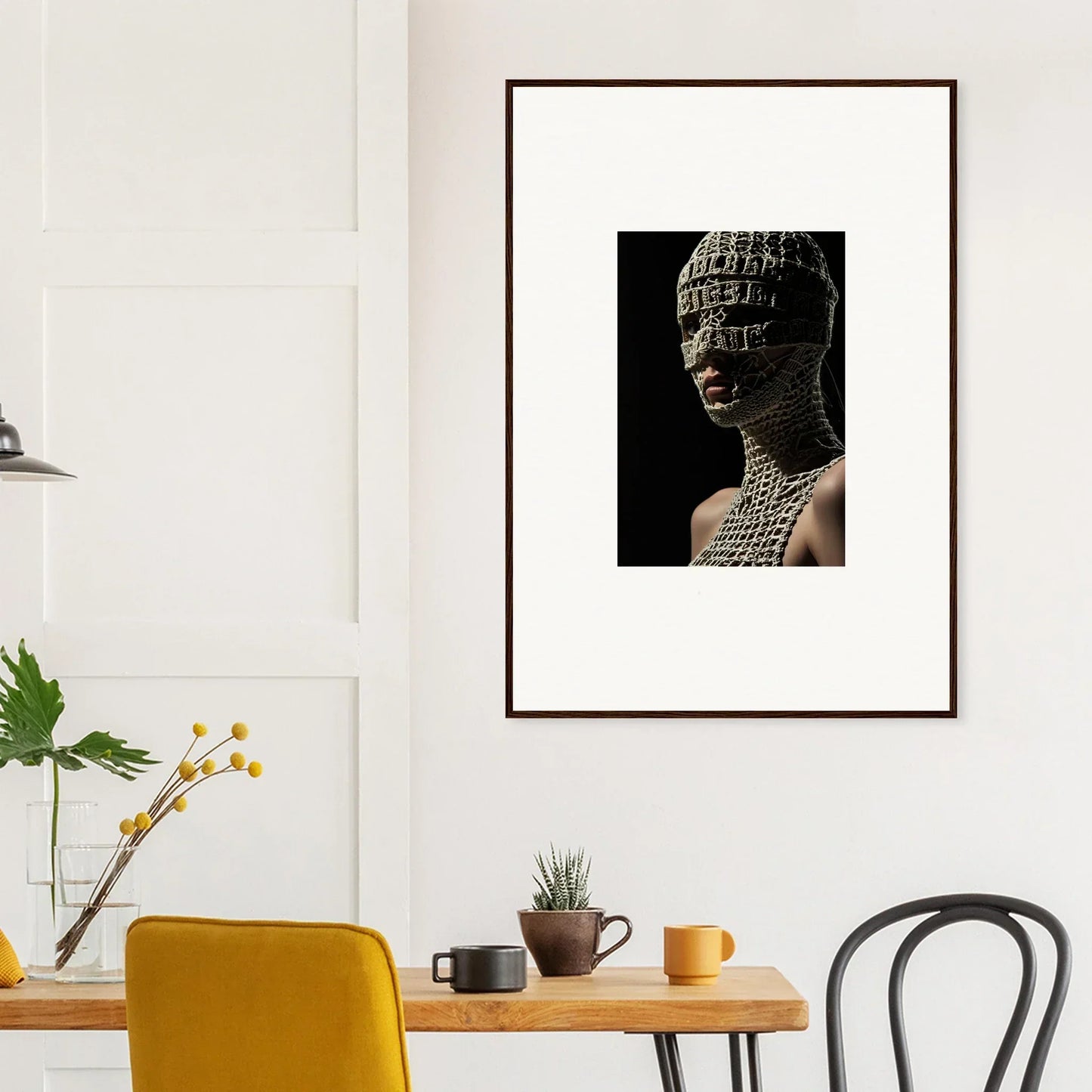 Framed artwork depicting a sculptural bust with intricate patterns on the face and head.