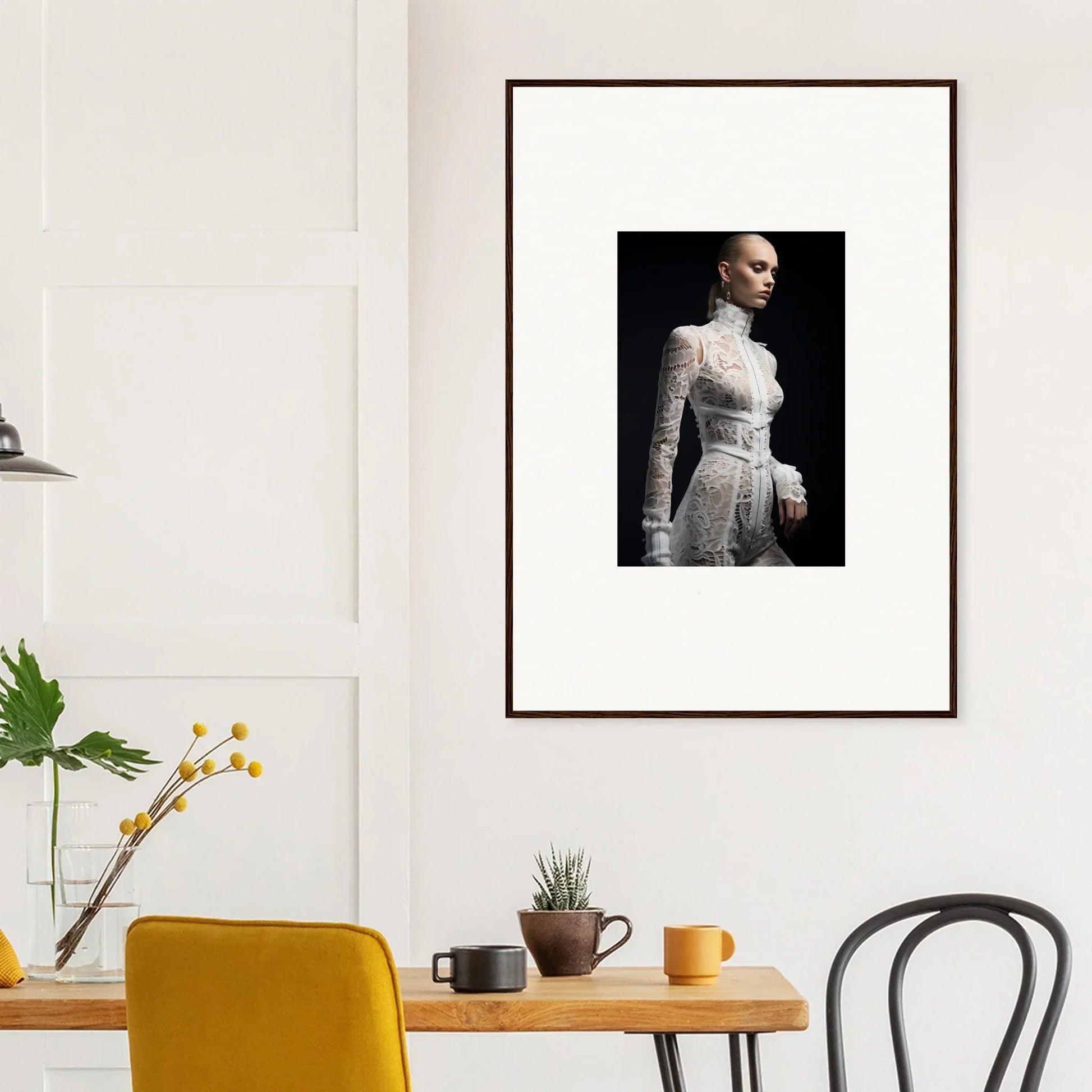 Framed black and white photograph of a person in a white high-necked dress against a dark background.