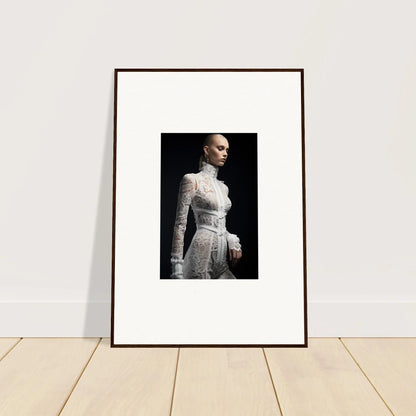 Framed photograph of a woman wearing an elegant white lace dress against a dark background.