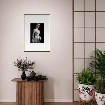 Framed black and white photograph of a person in a white dress against a dark background.