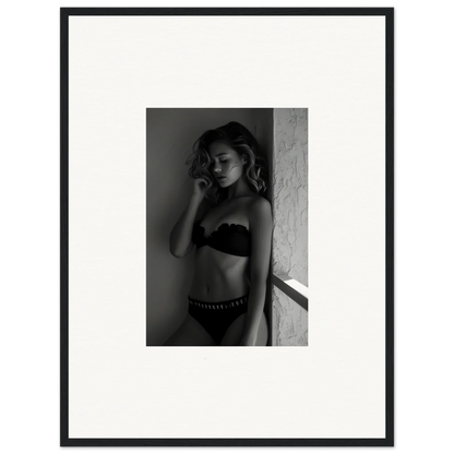 Black and white photograph of a woman in lingerie leaning against a wall.