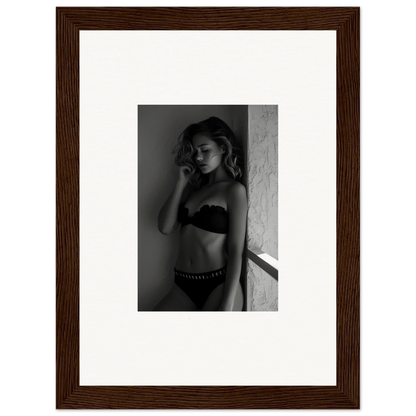 Black and white photograph of a woman in lingerie leaning against a wall.