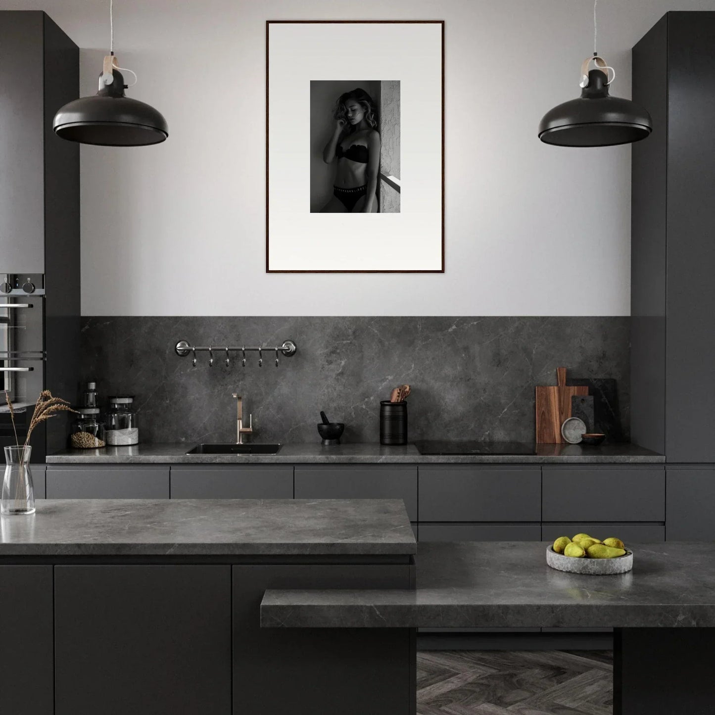 Modern kitchen with dark gray cabinetry and countertops, featuring pendant lights and a framed artwork on the wall.