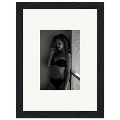 Black and white photograph of a woman in lingerie leaning against a wall.