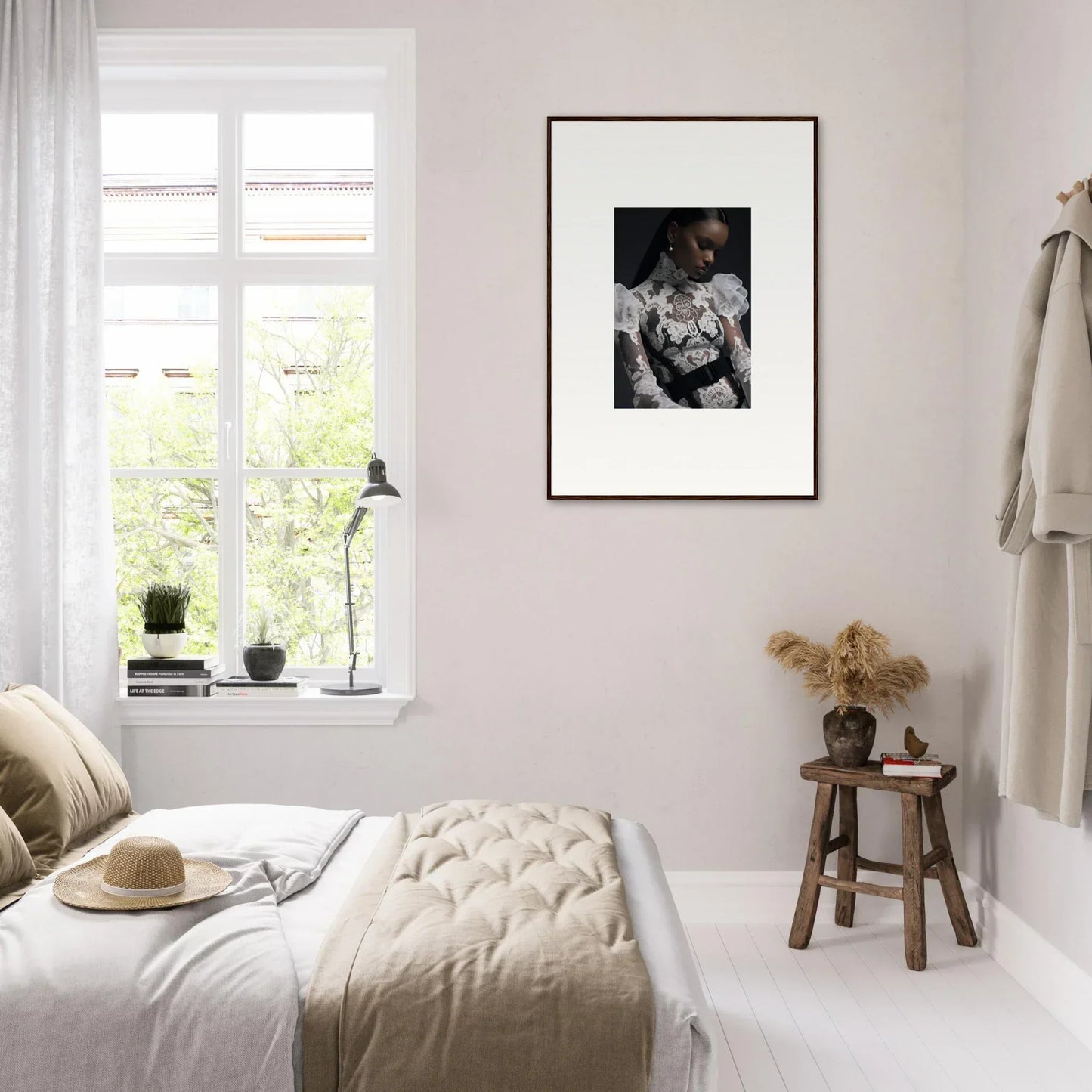 Bright, minimalist bedroom with a framed black and white photograph on the wall.