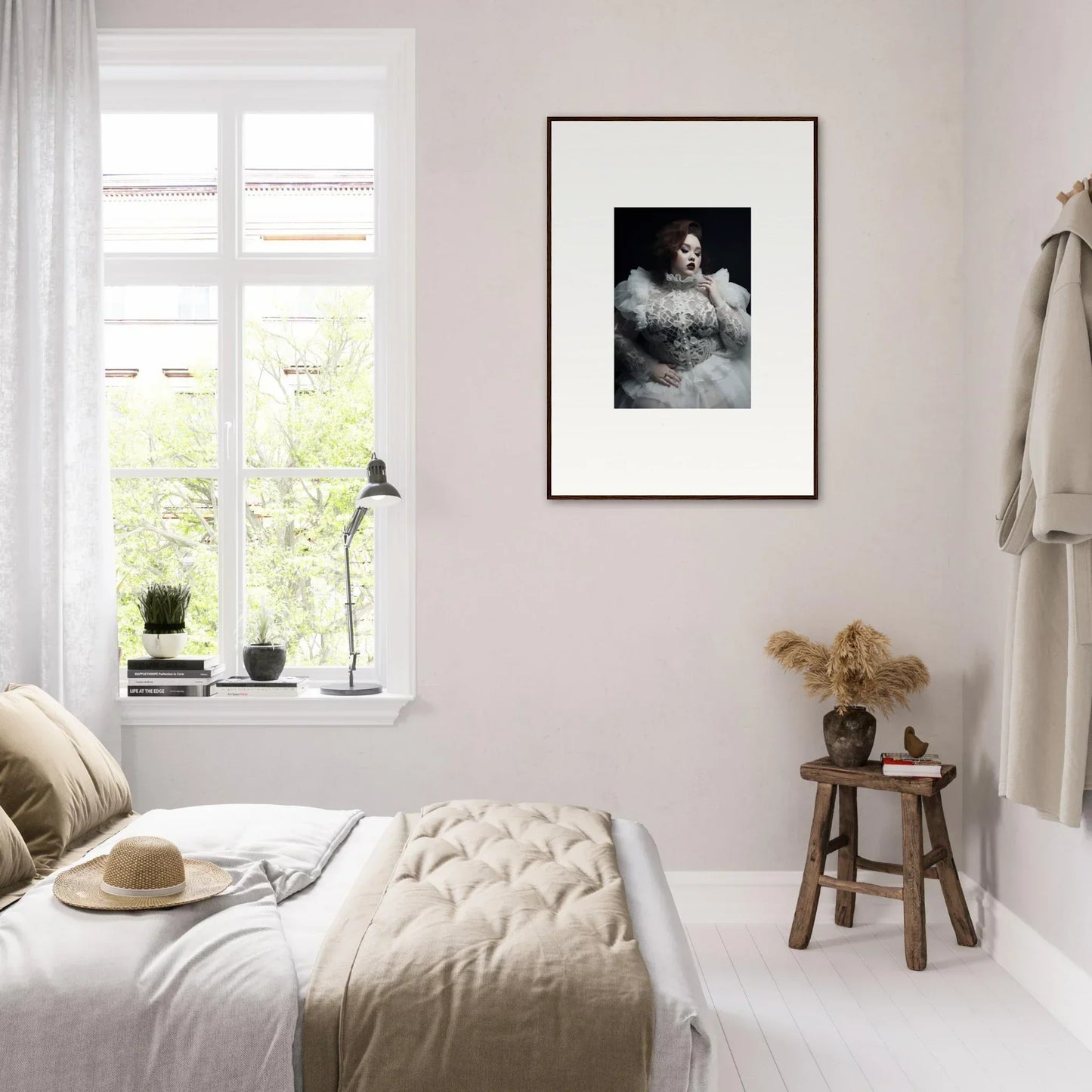 Cozy bedroom with neutral decor and a framed black and white portrait on the wall.