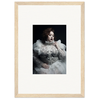 Framed black and white photograph of a woman in an ornate white dress with voluminous ruffles and lace details.