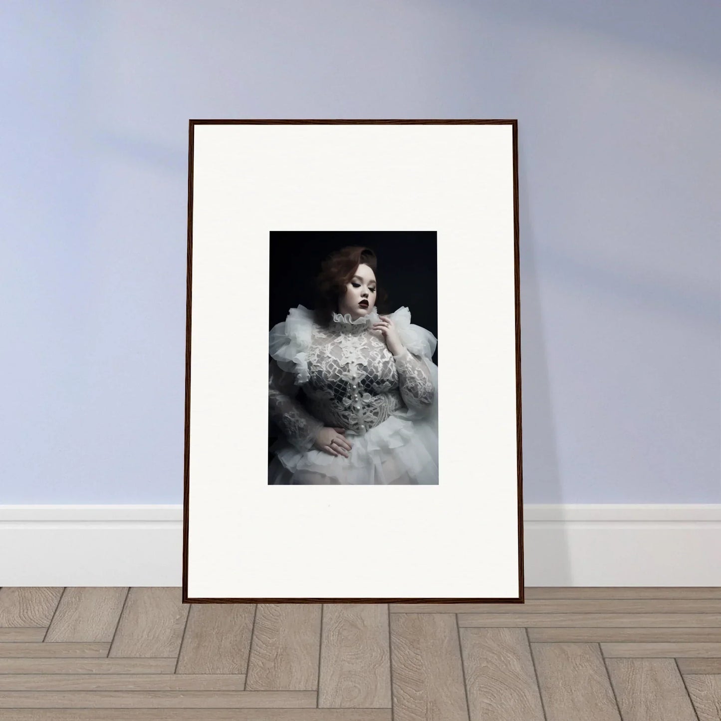 Framed black and white portrait photograph of a person wearing an elaborate, fluffy white gown.