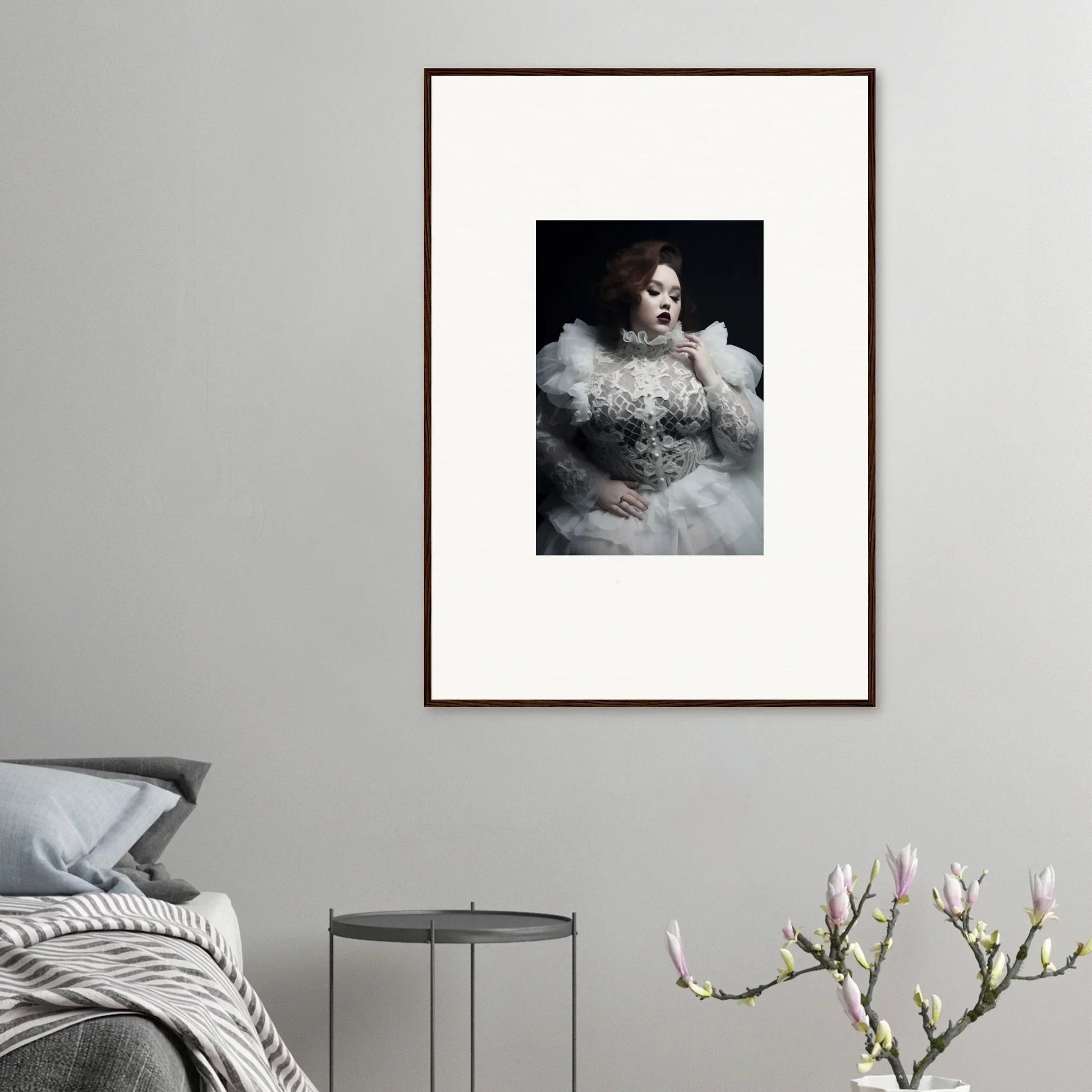 Framed portrait photograph of a person wearing an elaborate white feathered and beaded gown.