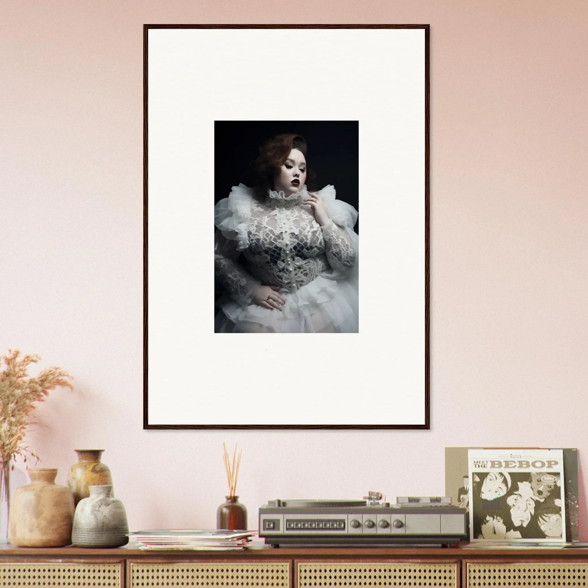 Framed portrait of a person wearing an elaborate white feathered and beaded costume against a dark background.