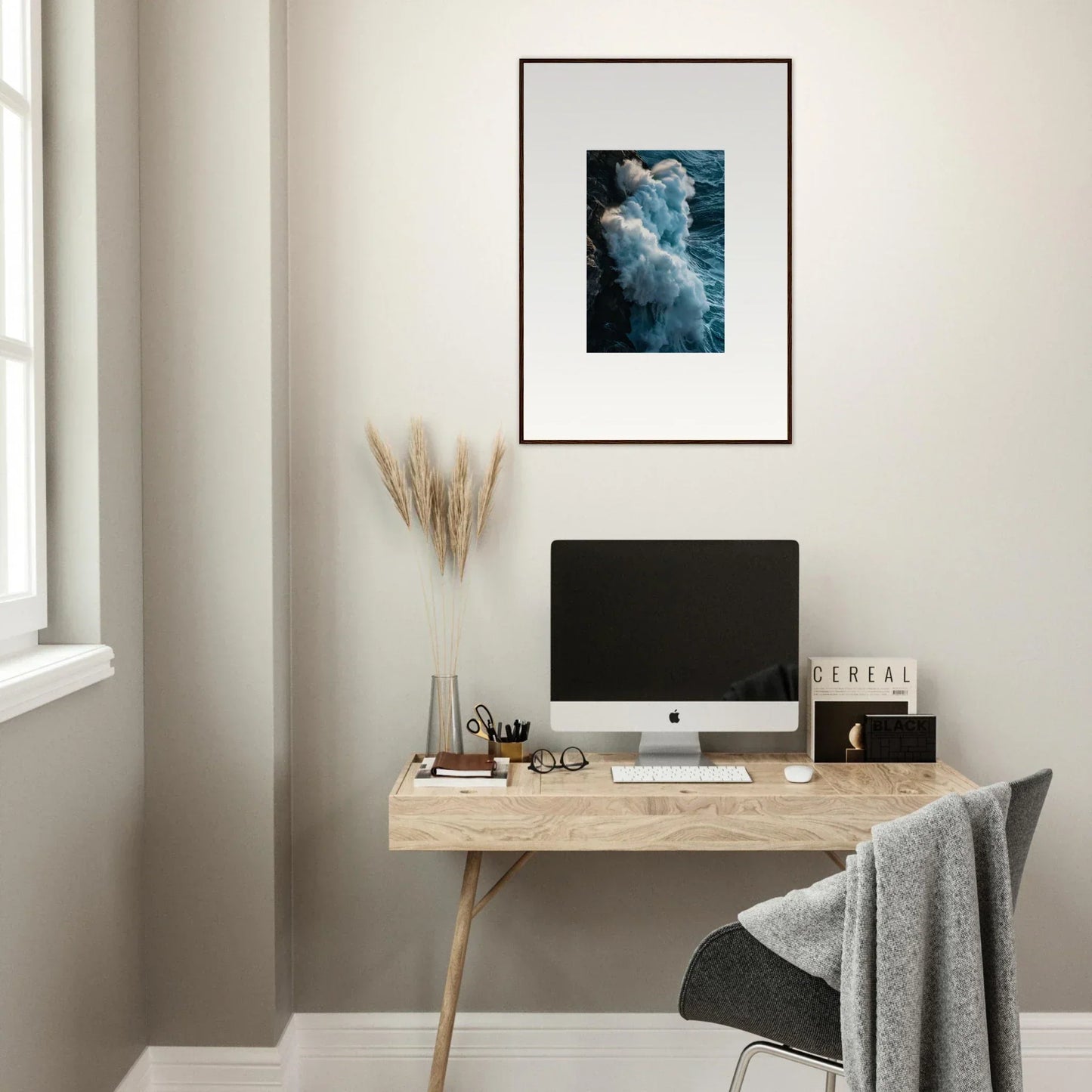 Stylish minimalist wooden desk with a computer and ocean wave wall art for room decoration