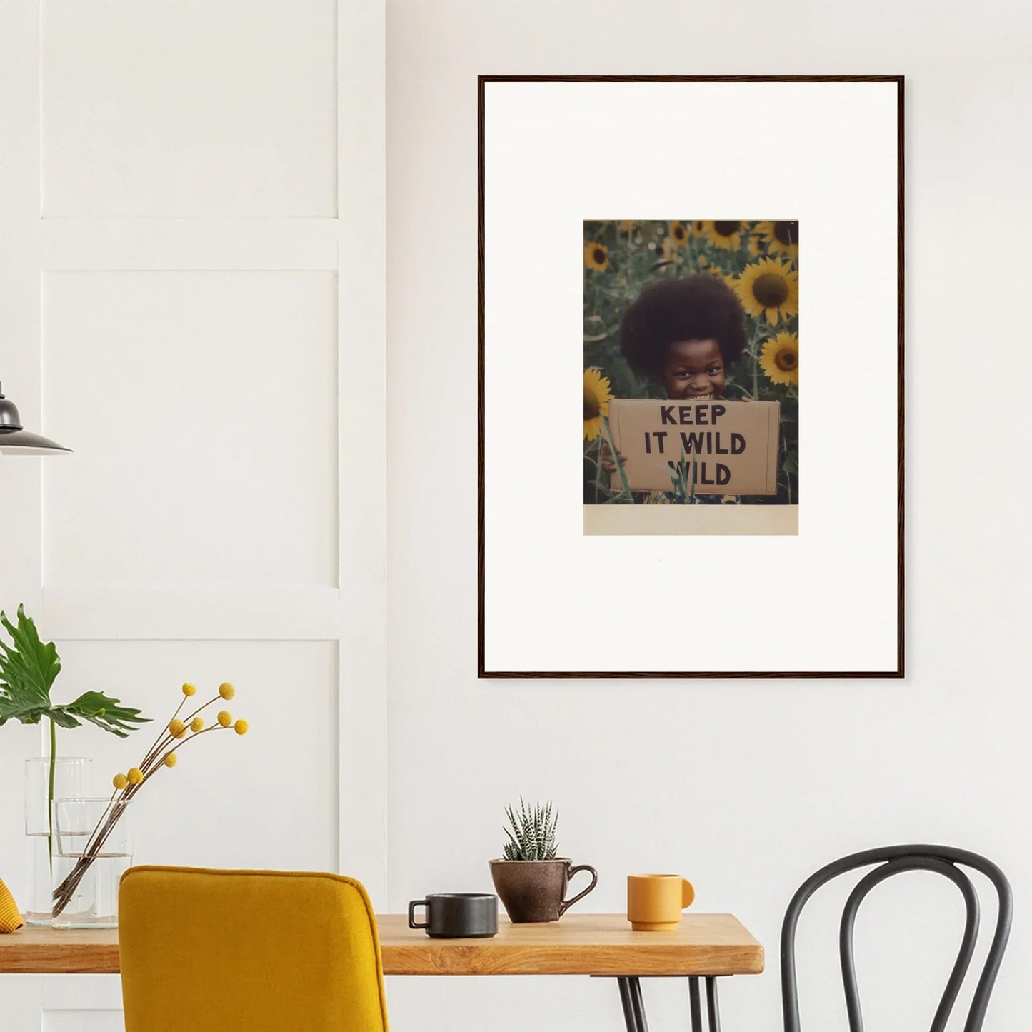 Framed Euphoric Sun Voyages artwork with sunflowers and Keep It Wild text on a wall