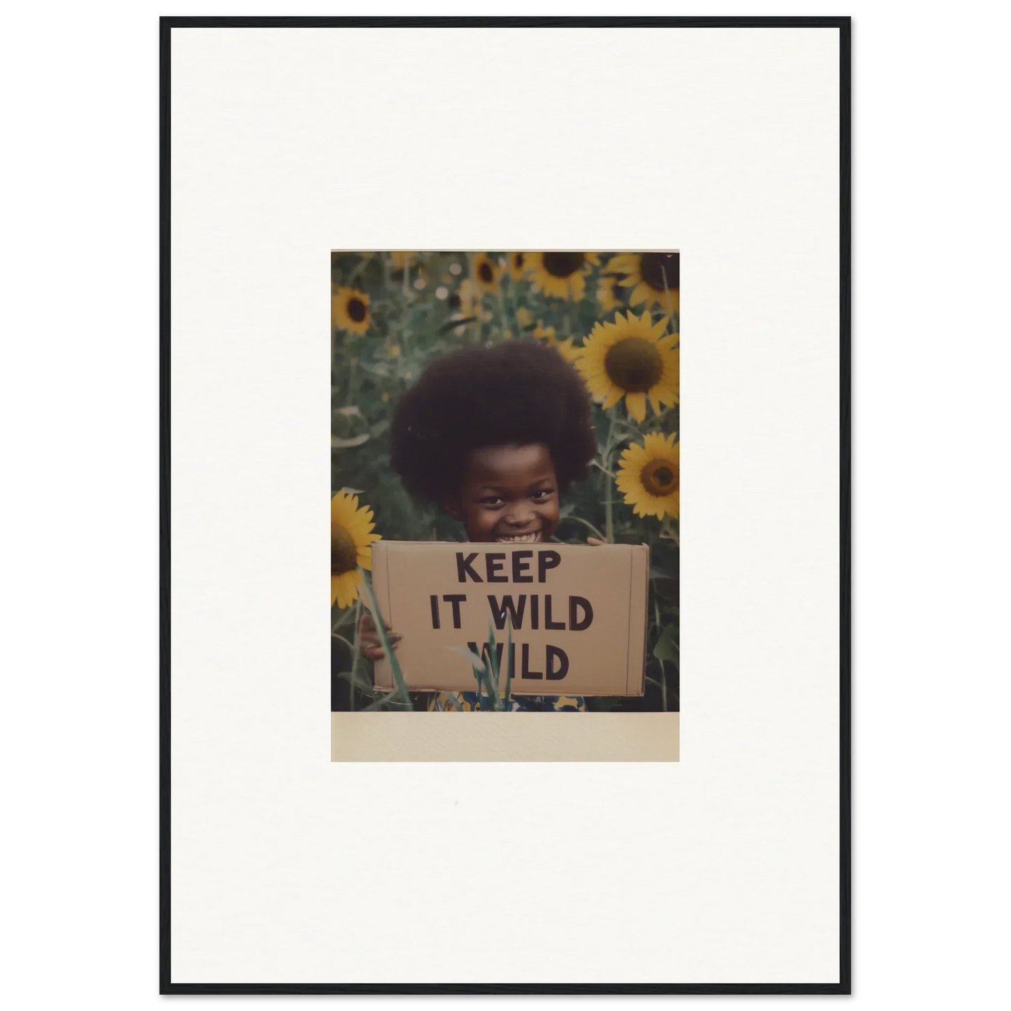 Framed vintage photo of a person with a KEEP IT WILD sign in sunflowers for Euphoric Sun Voyages