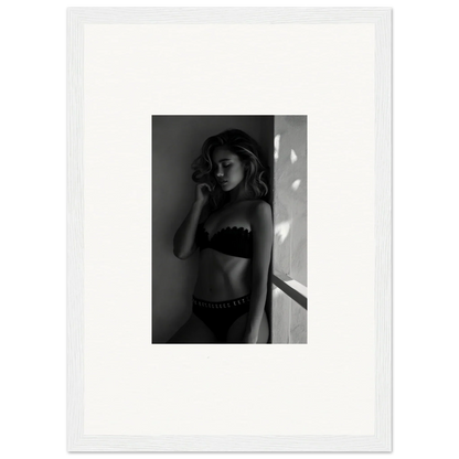 Black and white photograph of a woman in lingerie standing near a window.