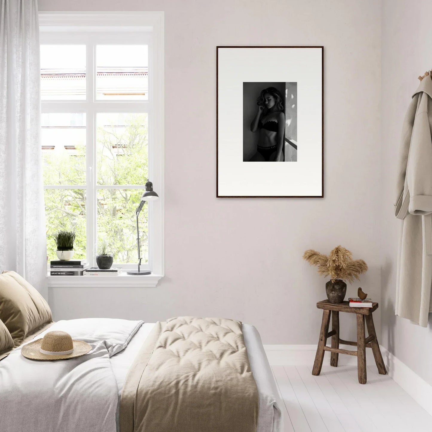 Cozy bedroom with neutral decor and a framed black and white photograph on the wall.