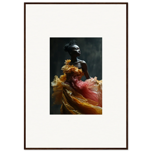 Framed photograph of a person wearing flowing, colorful fabric against a dark background.