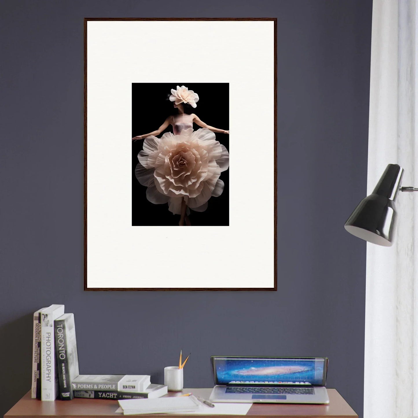 Framed artwork depicting a figure emerging from or merging with a large, pale flower against a dark background.