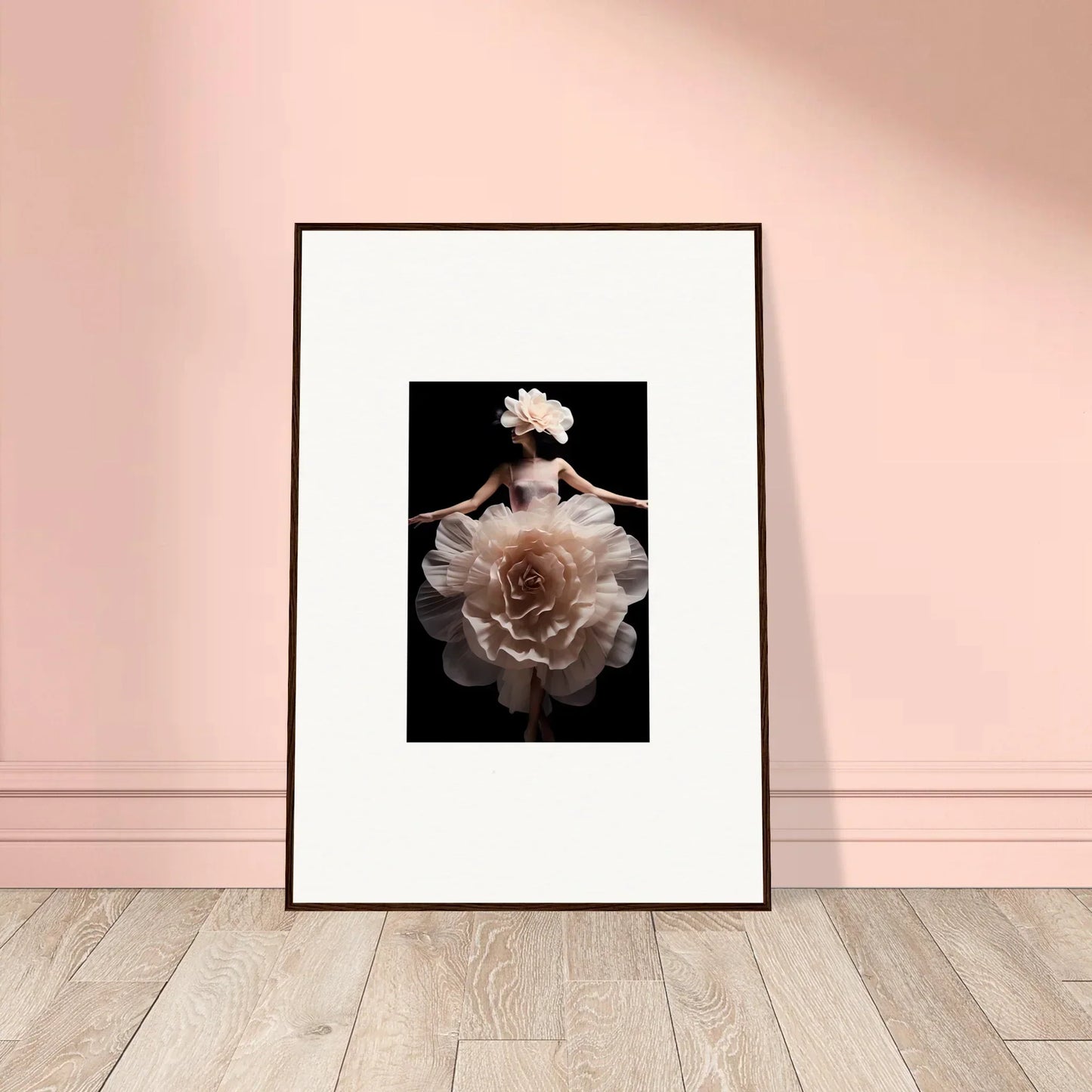 Framed photograph of a figure wearing an elaborate floral dress against a dark background.