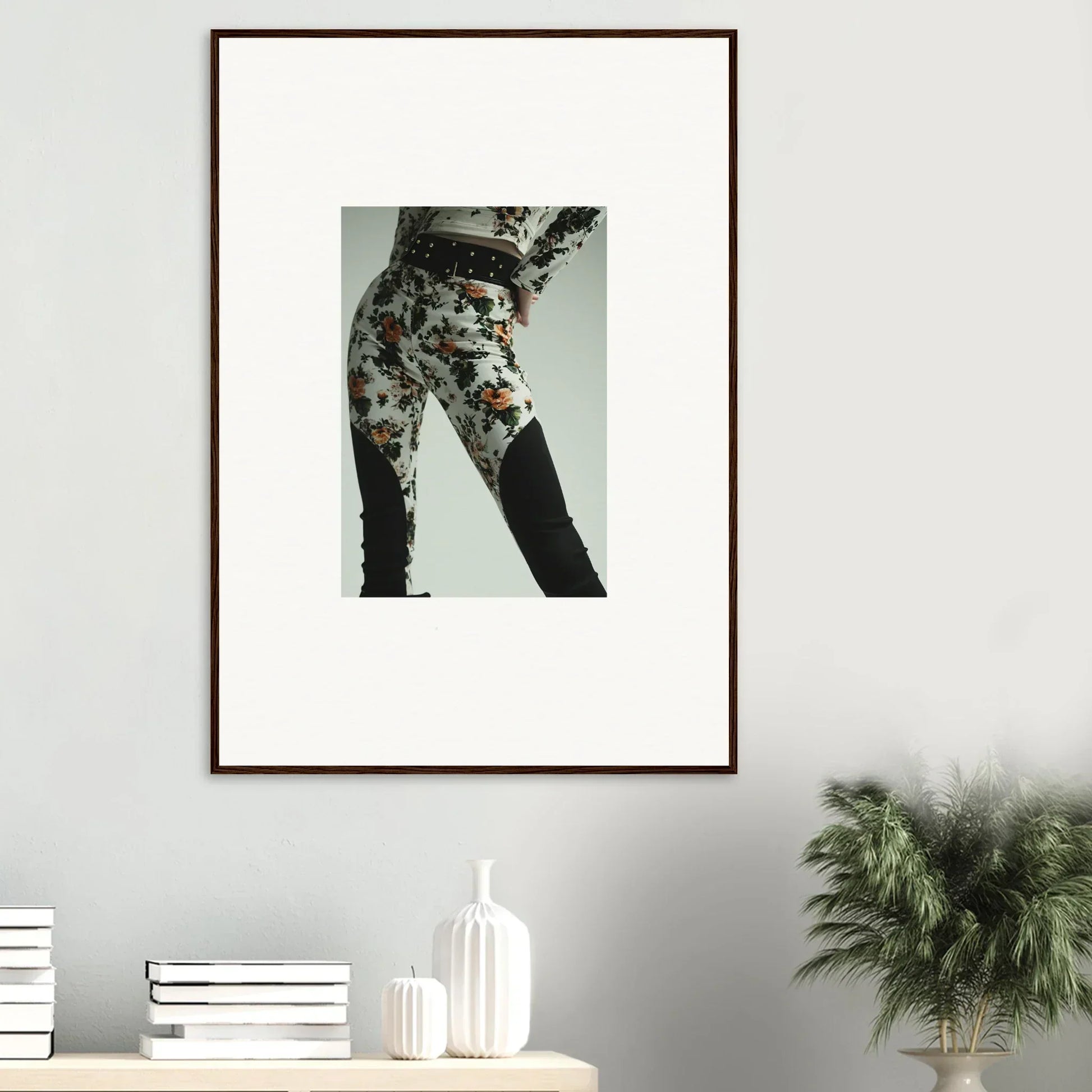 Framed artwork showing a close-up of floral-patterned pants on a person’s lower body.