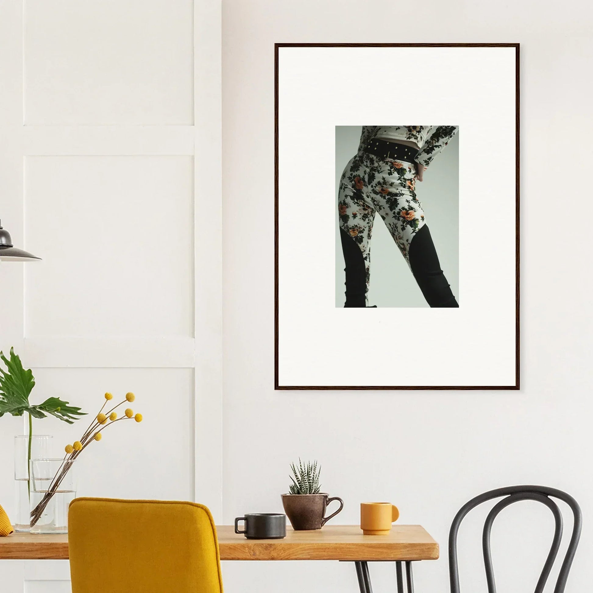 Framed photograph of a person’s lower body wearing floral patterned pants.