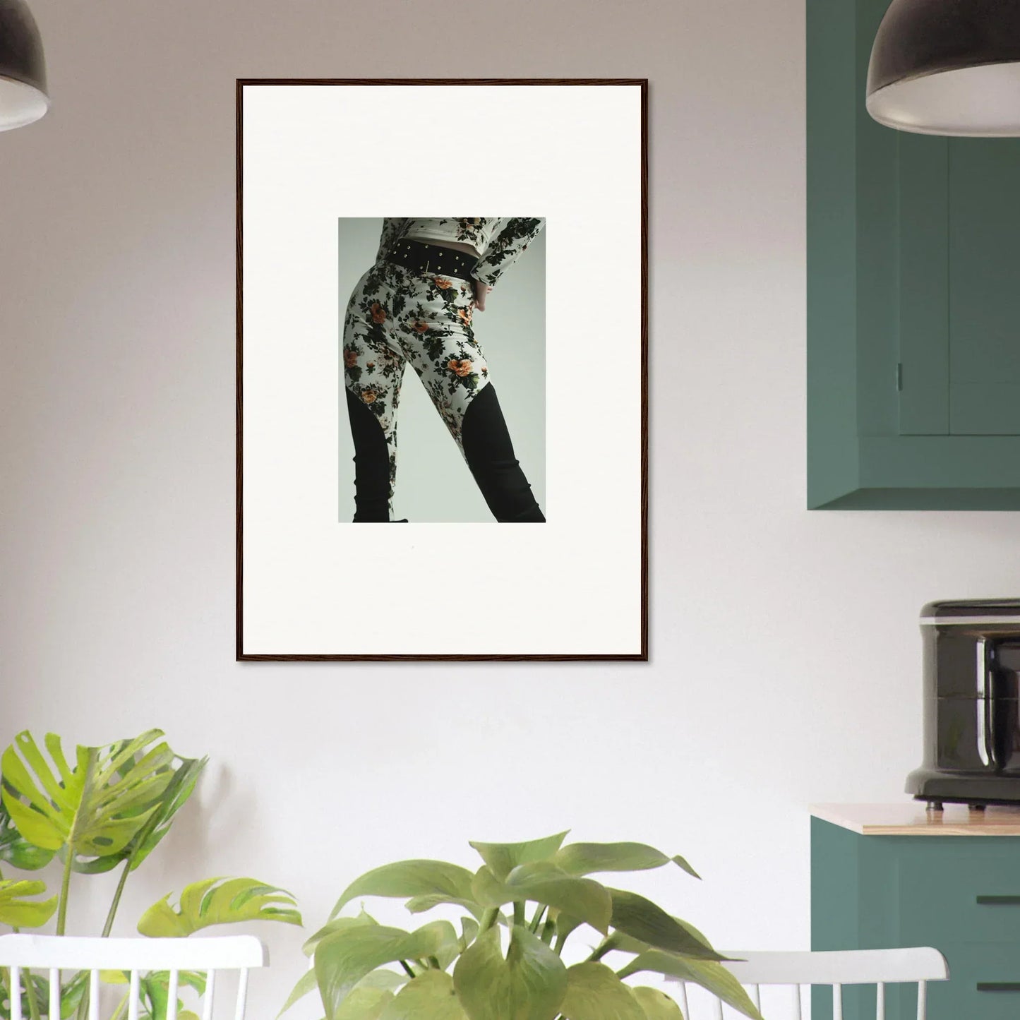 Framed artwork depicting a person’s lower body wearing floral patterned pants.