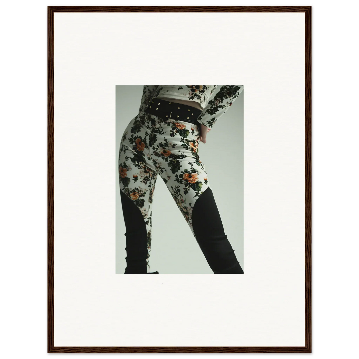 Framed photograph of a person wearing floral-patterned pants with black knee patches.