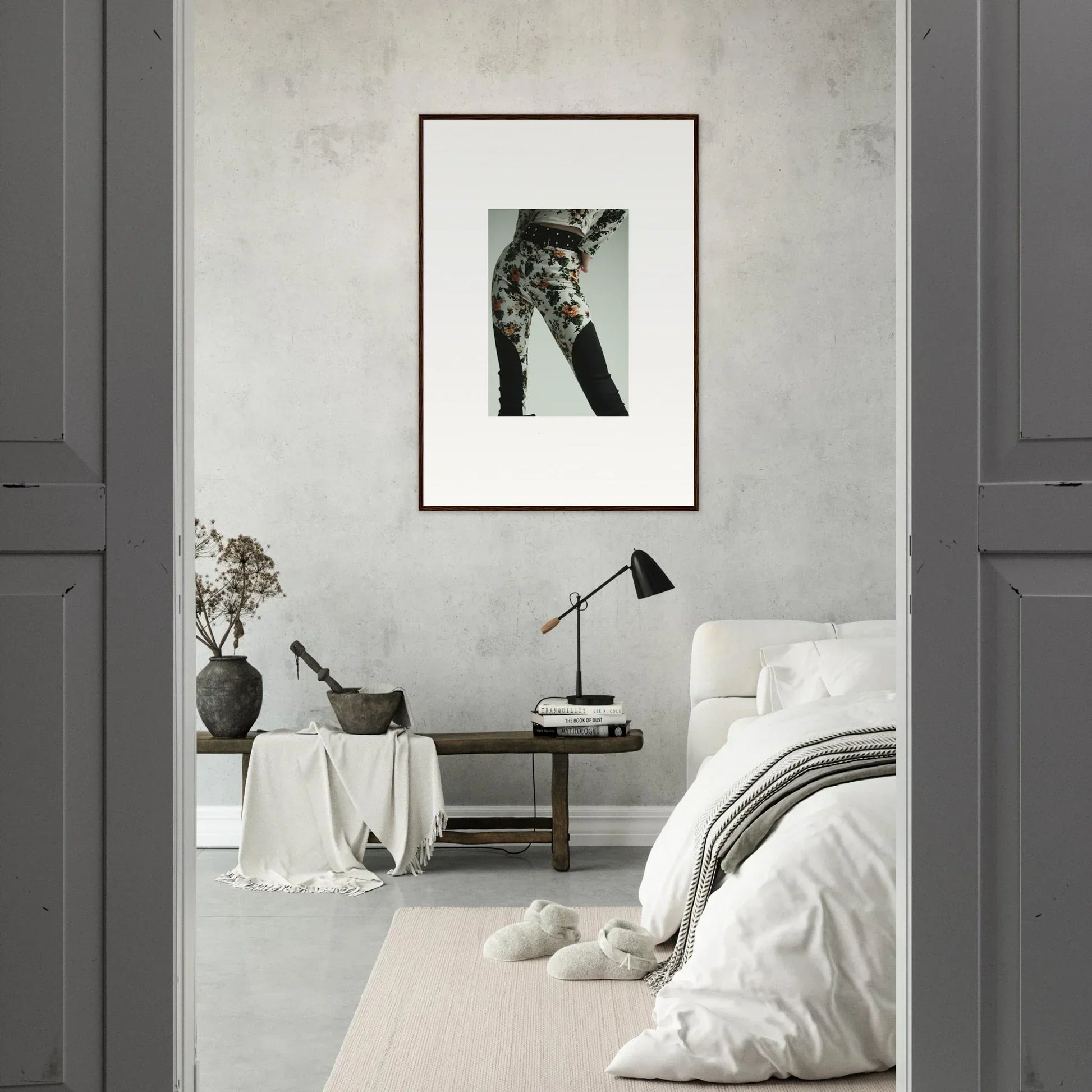 Monochromatic bedroom interior with minimalist decor and framed wall art.