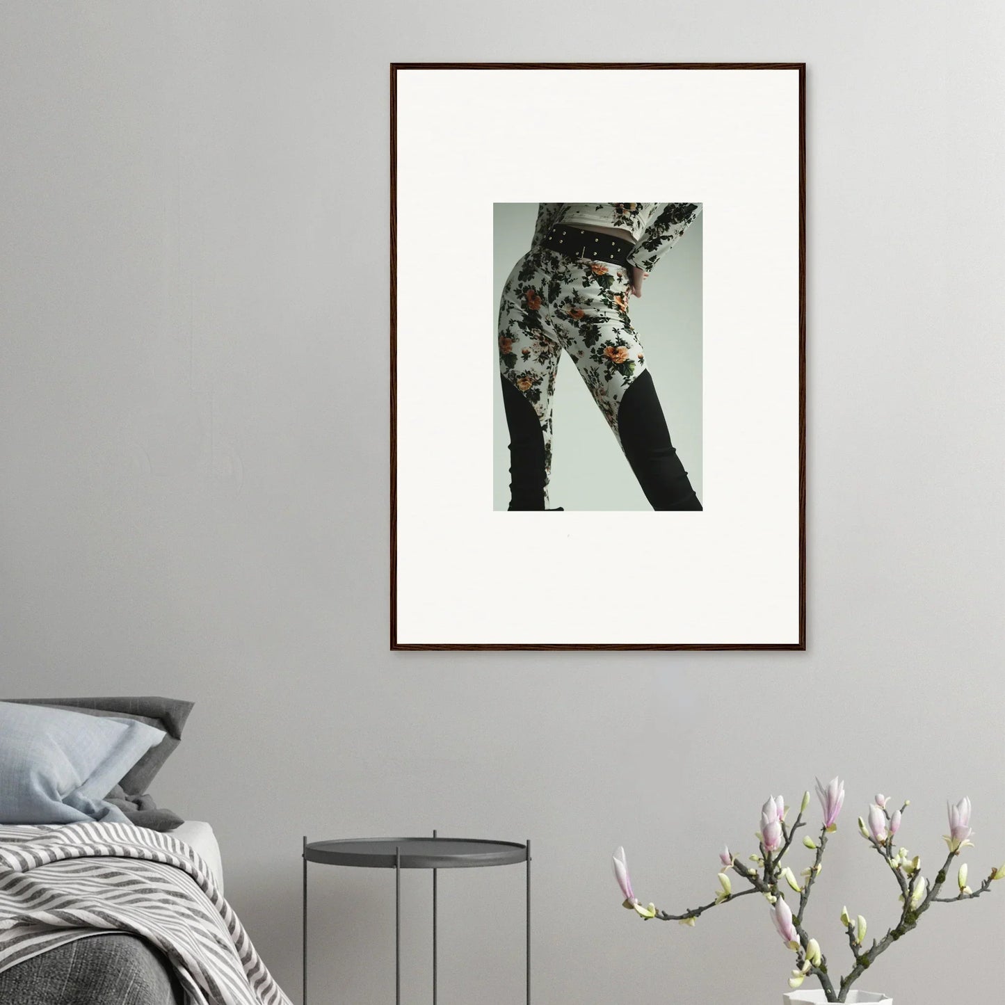 Framed artwork showing a person’s lower body wearing floral patterned pants.