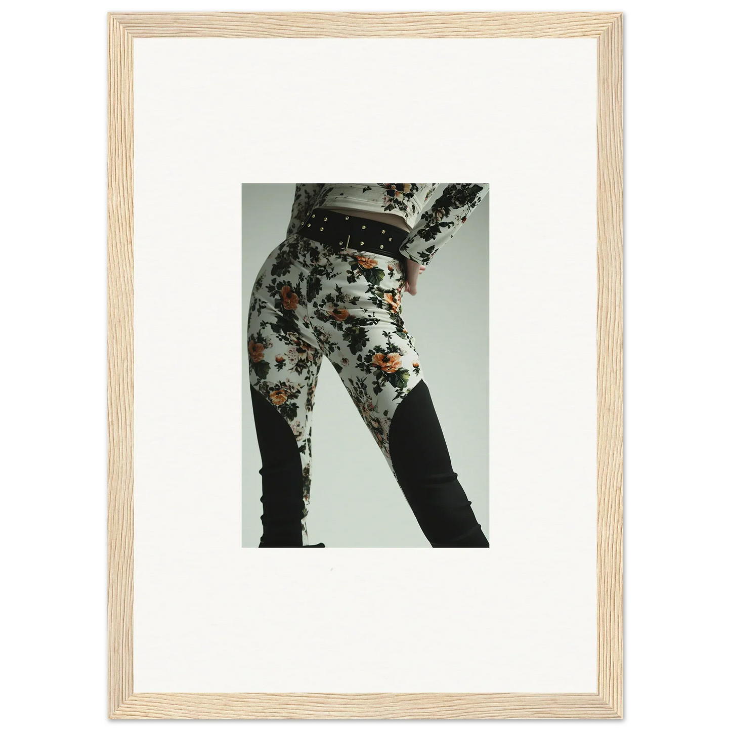 Framed photograph of a person wearing patterned pants and dark boots.