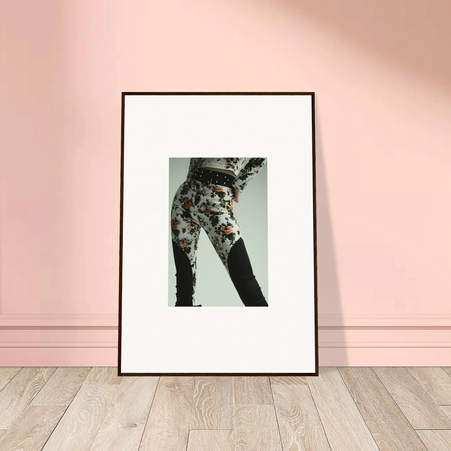 Framed black-and-white photograph of a person wearing floral patterned pants.