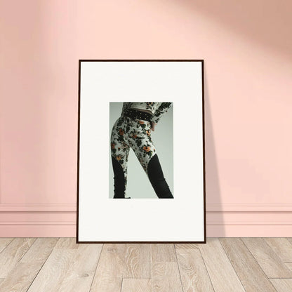 Framed black-and-white photograph of a person wearing floral patterned pants.