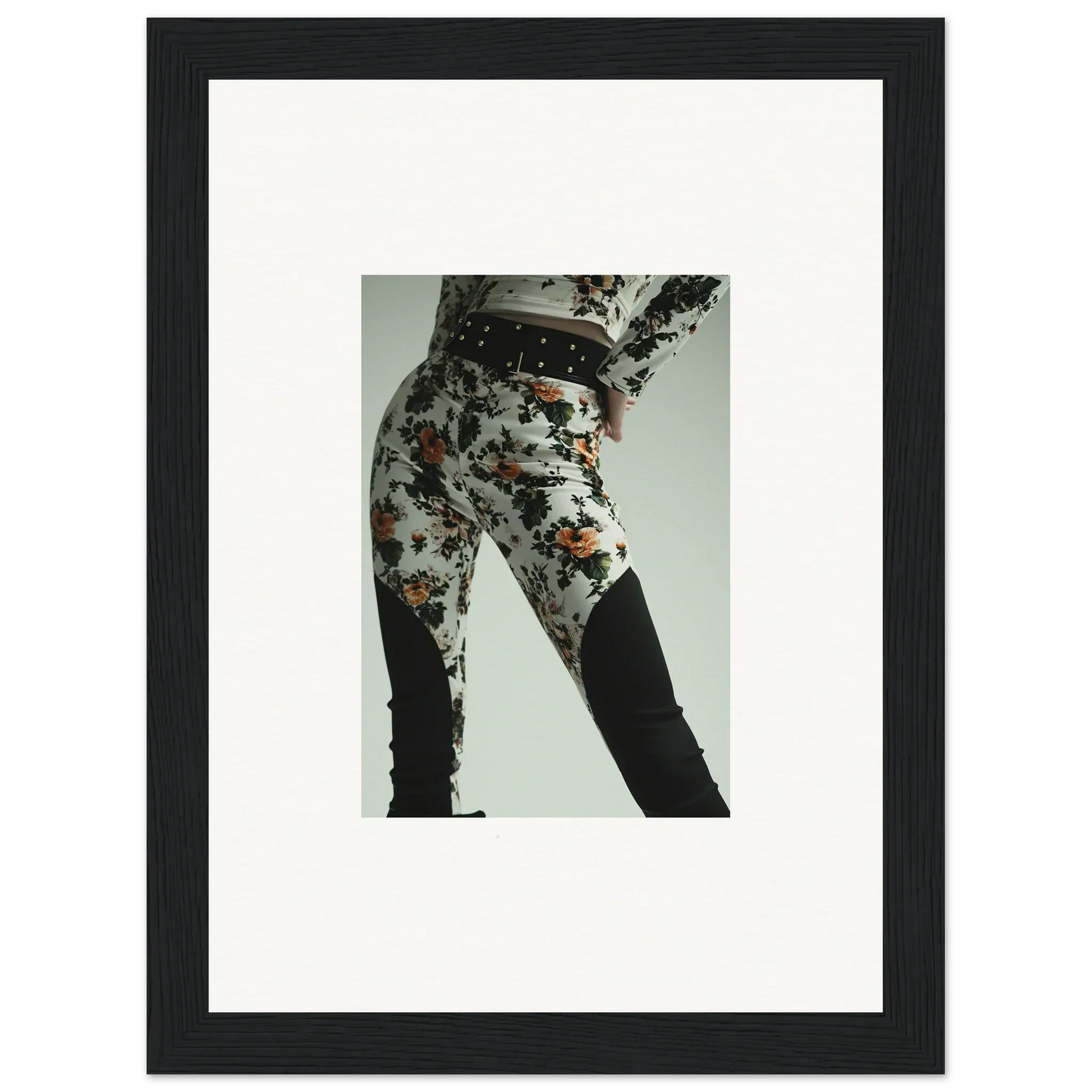 Framed photograph of a person’s lower body wearing floral patterned pants.