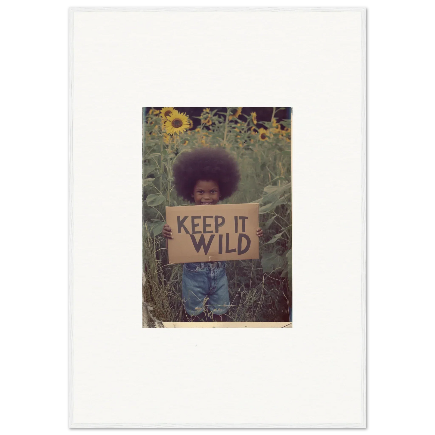 Person with KEEP IT WILD sign in plants and sunflowers for a chill room decoration