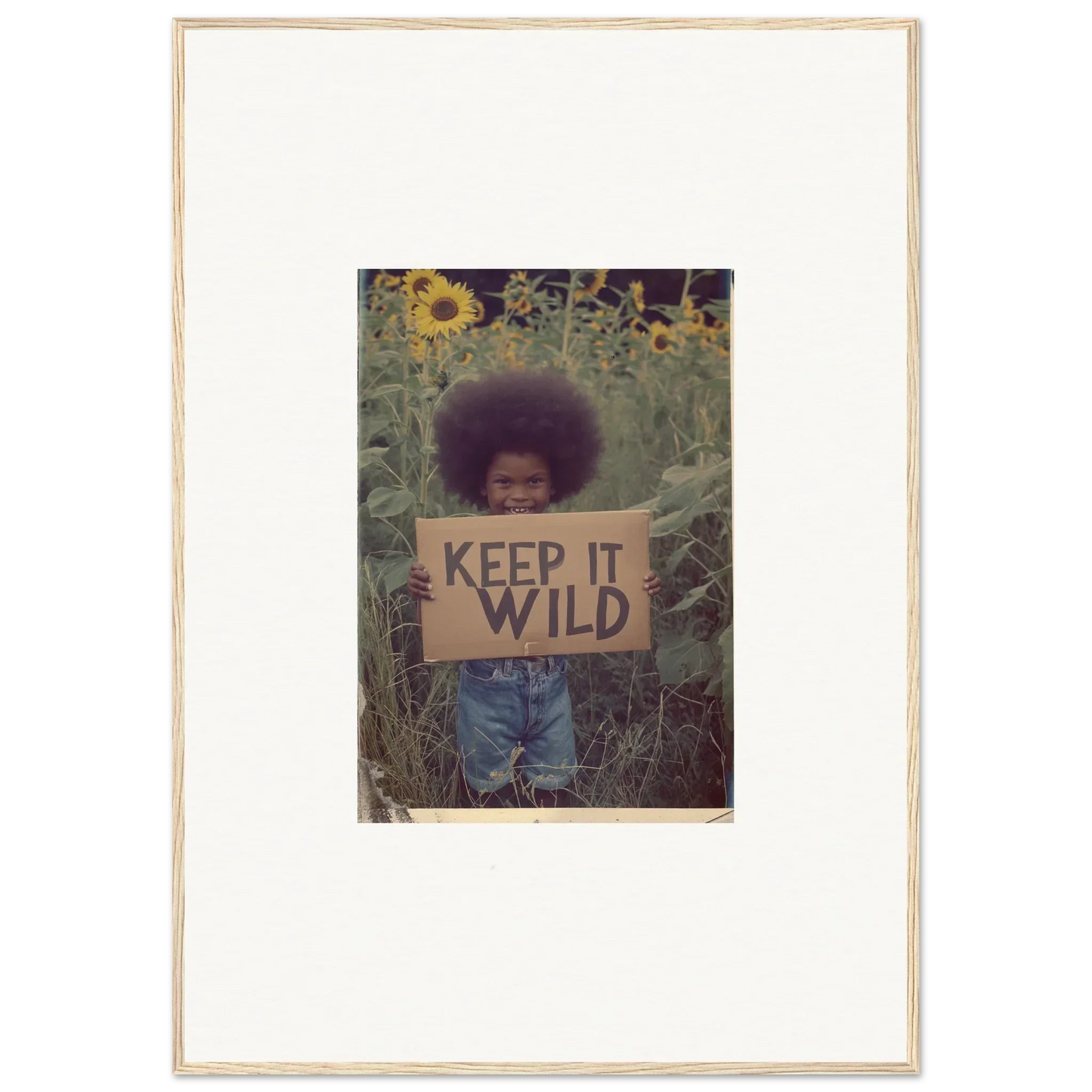 Framed photo of a person with a KEEP IT WILD sign among sunflowers for room decoration