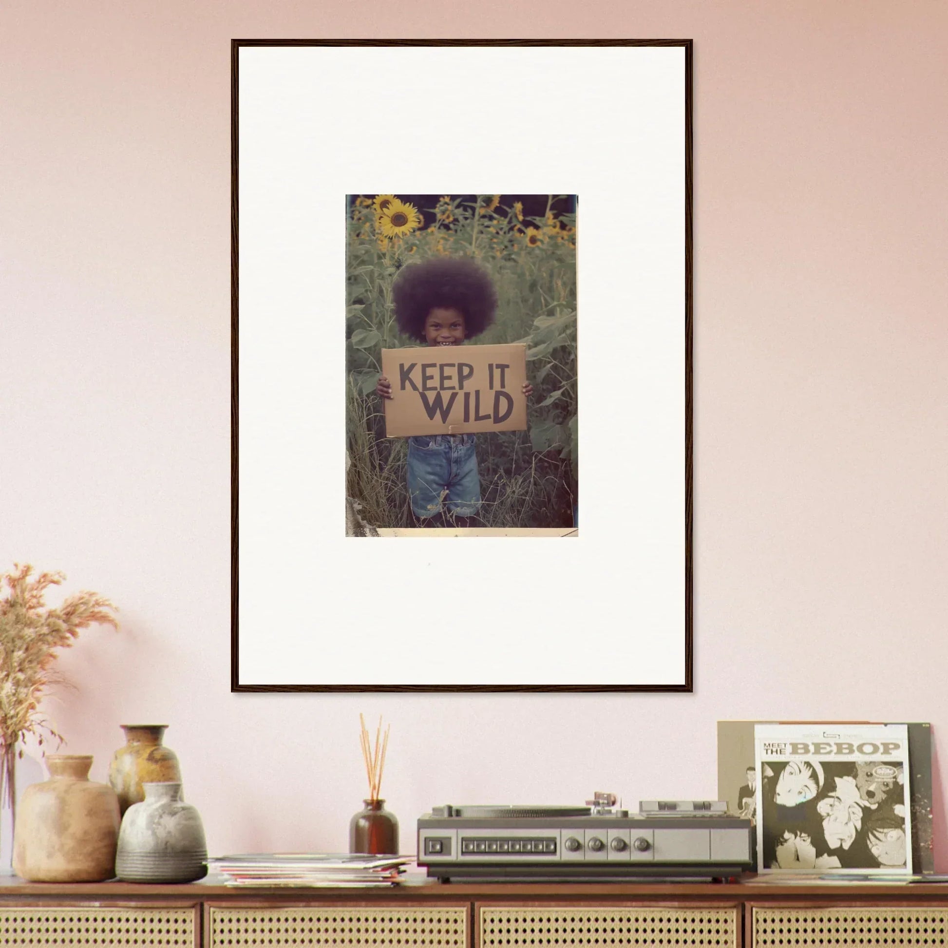 Framed photograph of a person with KEEP IT WILD sign in sunflower field for room decoration