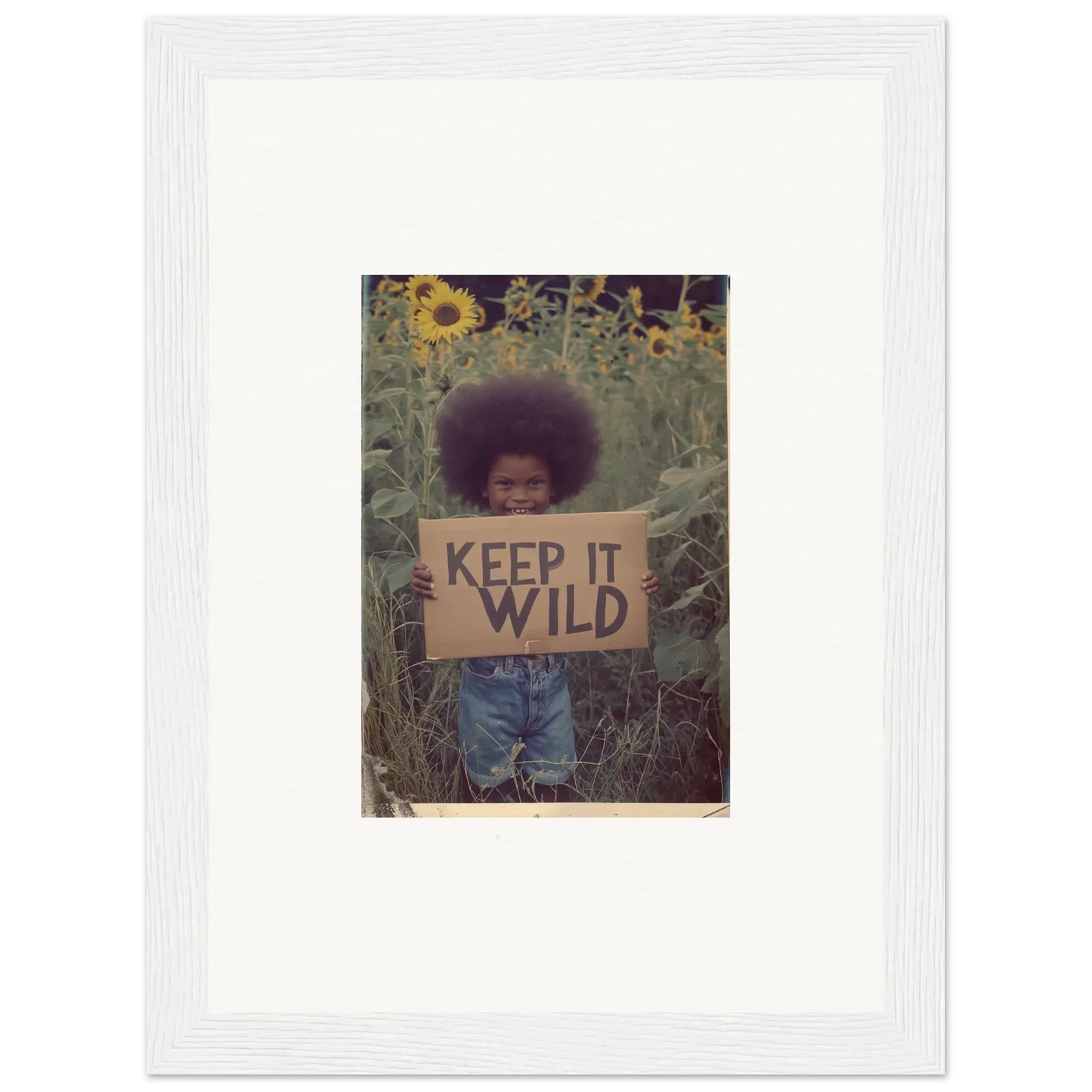 Framed photo of a person with an afro holding a KEEP IT WILD sign for room decoration