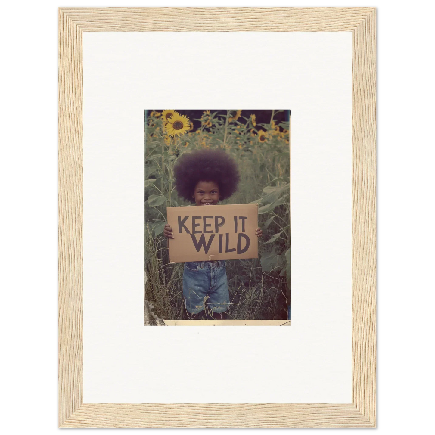 Framed photo of person with KEEP IT WILD sign in sunflower field for room decoration