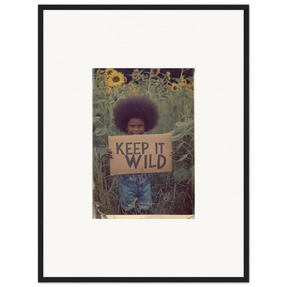 Framed canvas print of a person with an afro in a sunflower field with a KEEP IT WILD sign