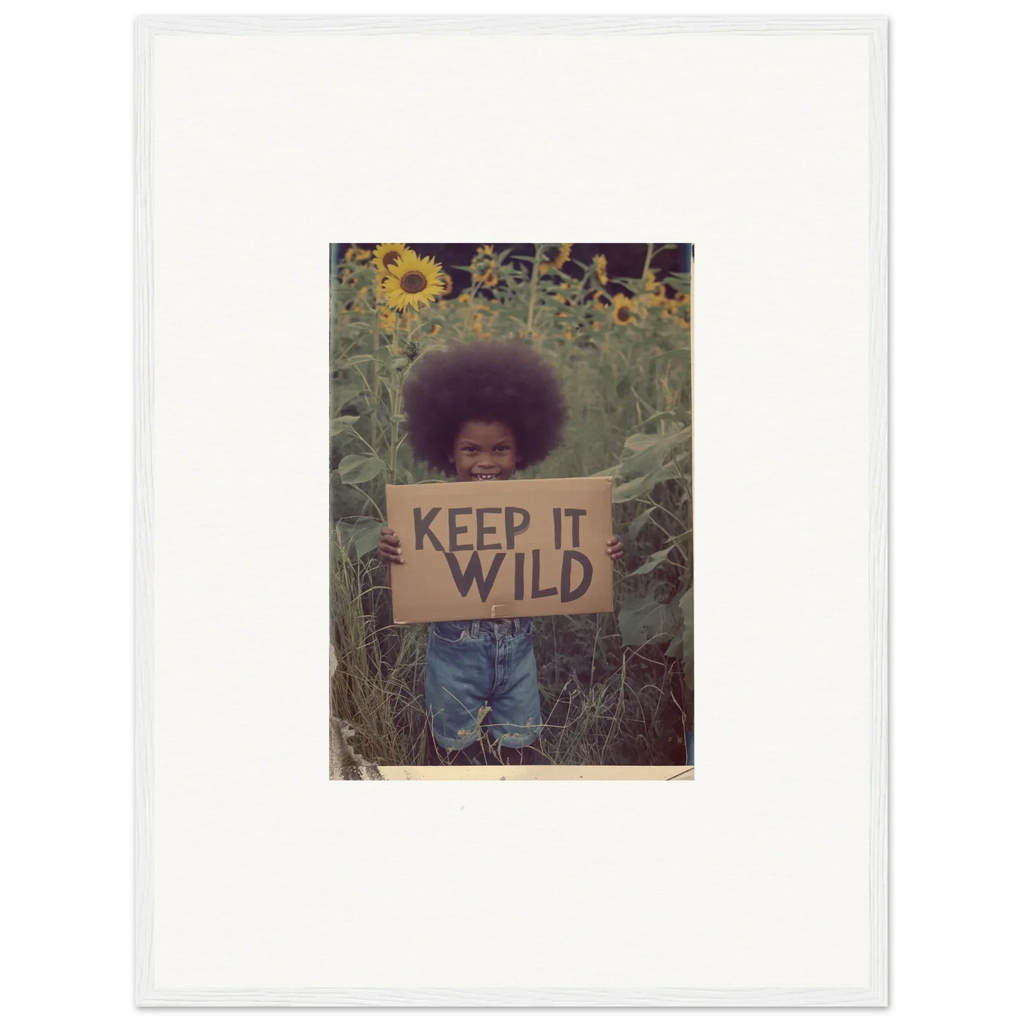 Framed canvas print of a person with an afro and KEEP IT WILD sign in sunflowers