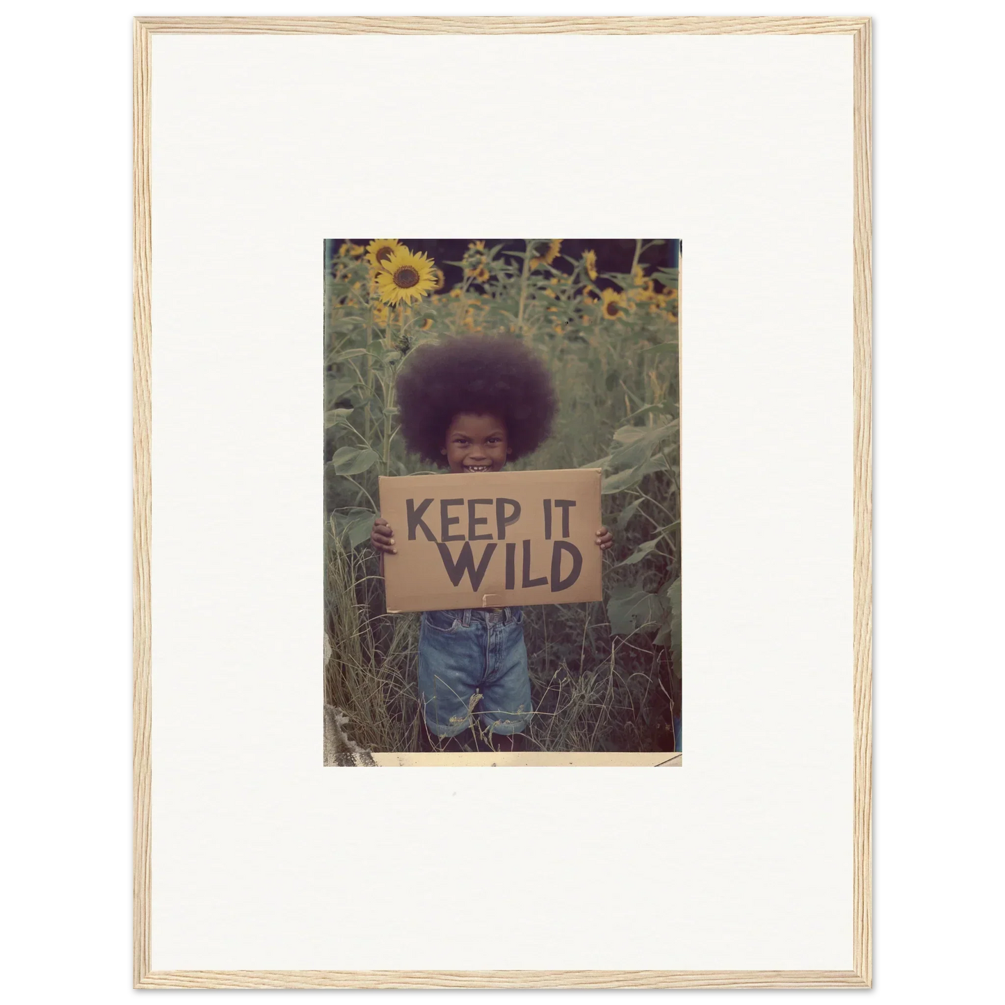 Framed photo of someone with a KEEP IT WILD sign in a sunflower field, perfect room decoration