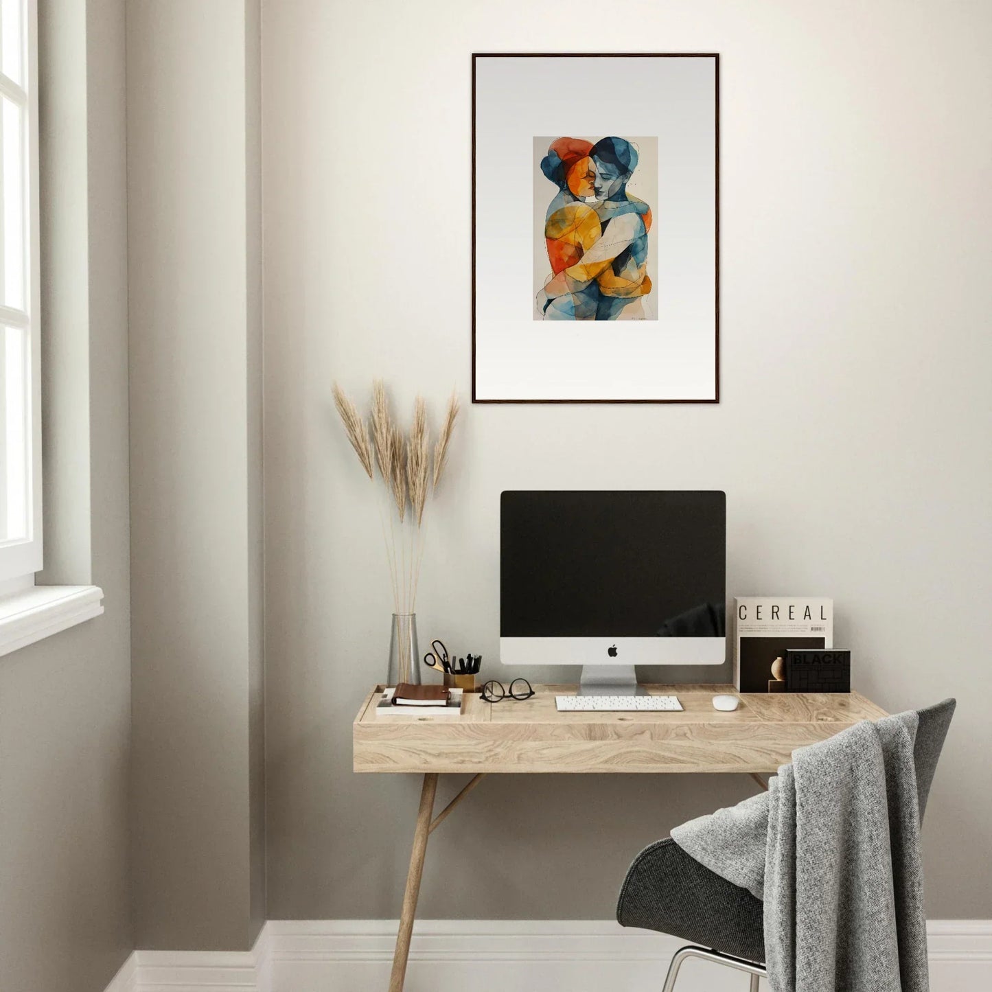 Minimalist home office with wooden desk, computer, and Souls Embrace framed wall art