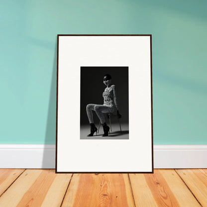 Framed black and white photograph of a person sitting on a chair.