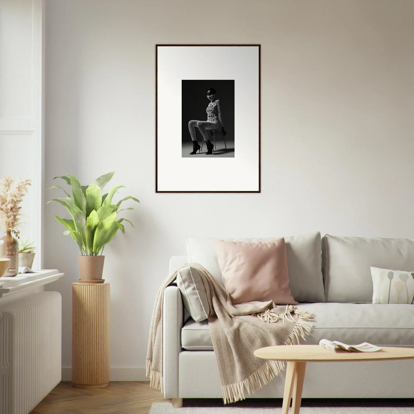 Framed black and white photograph of a seated figure hanging on a wall.