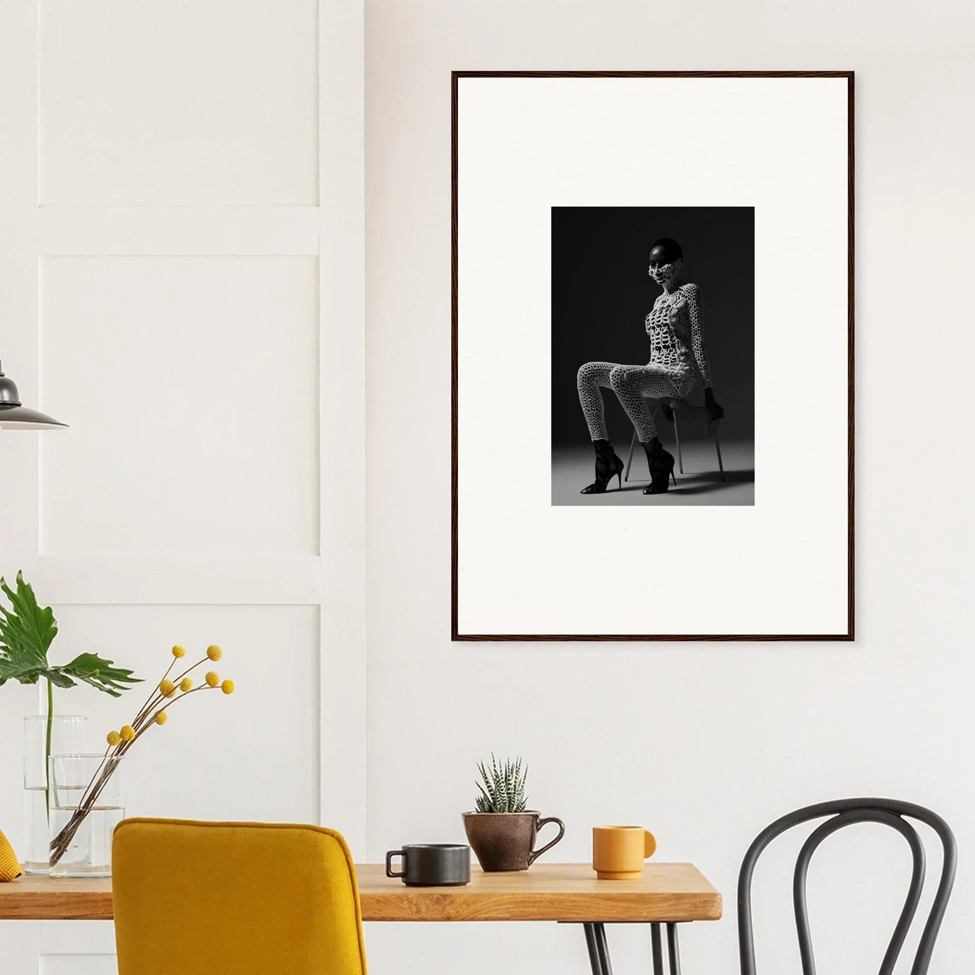 Framed black and white photograph of a person sitting on a chair.