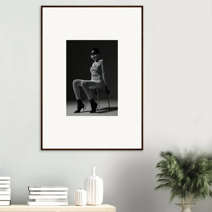 Framed black and white photograph of a person sitting on a stool.