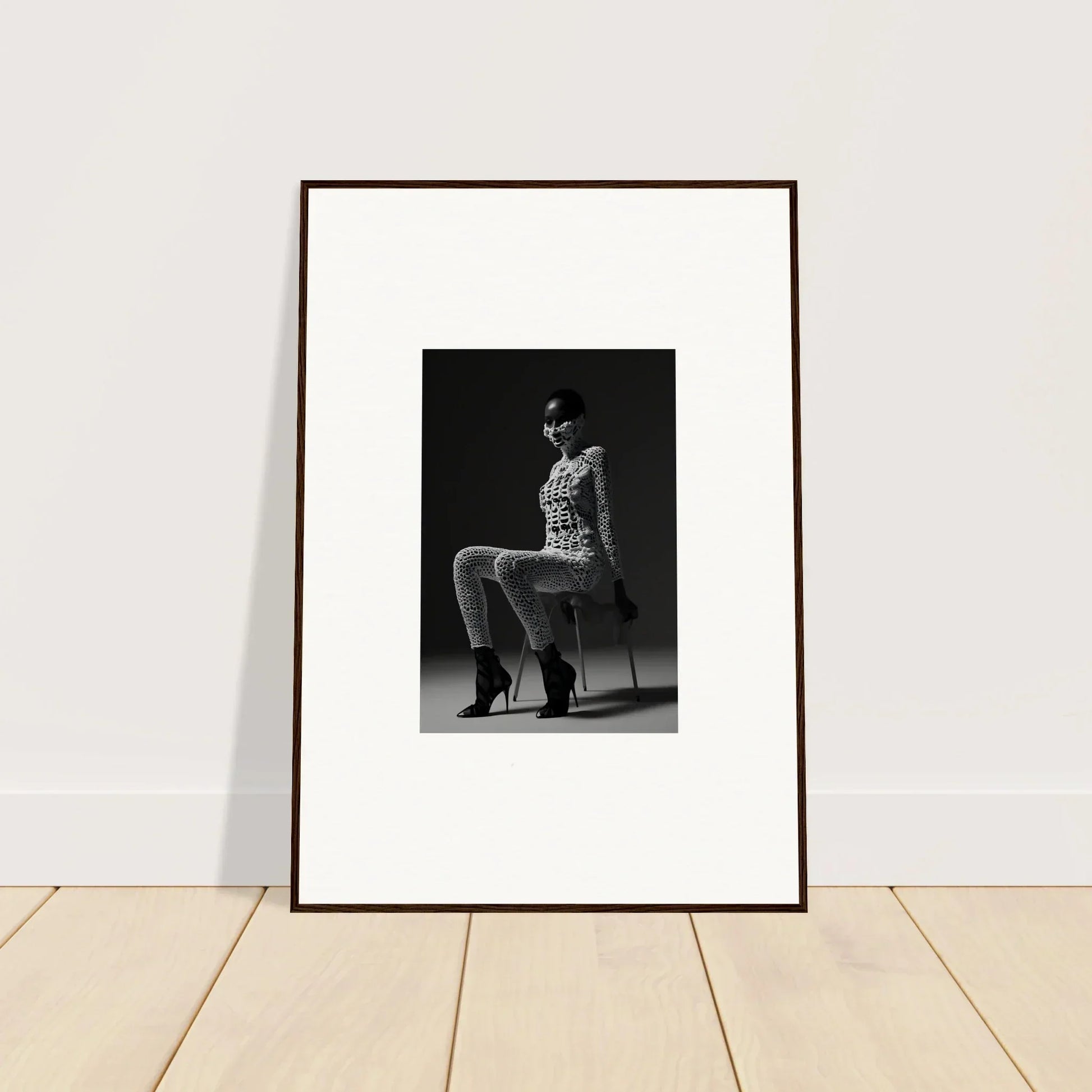 Framed black and white photograph of a person seated on a chair.