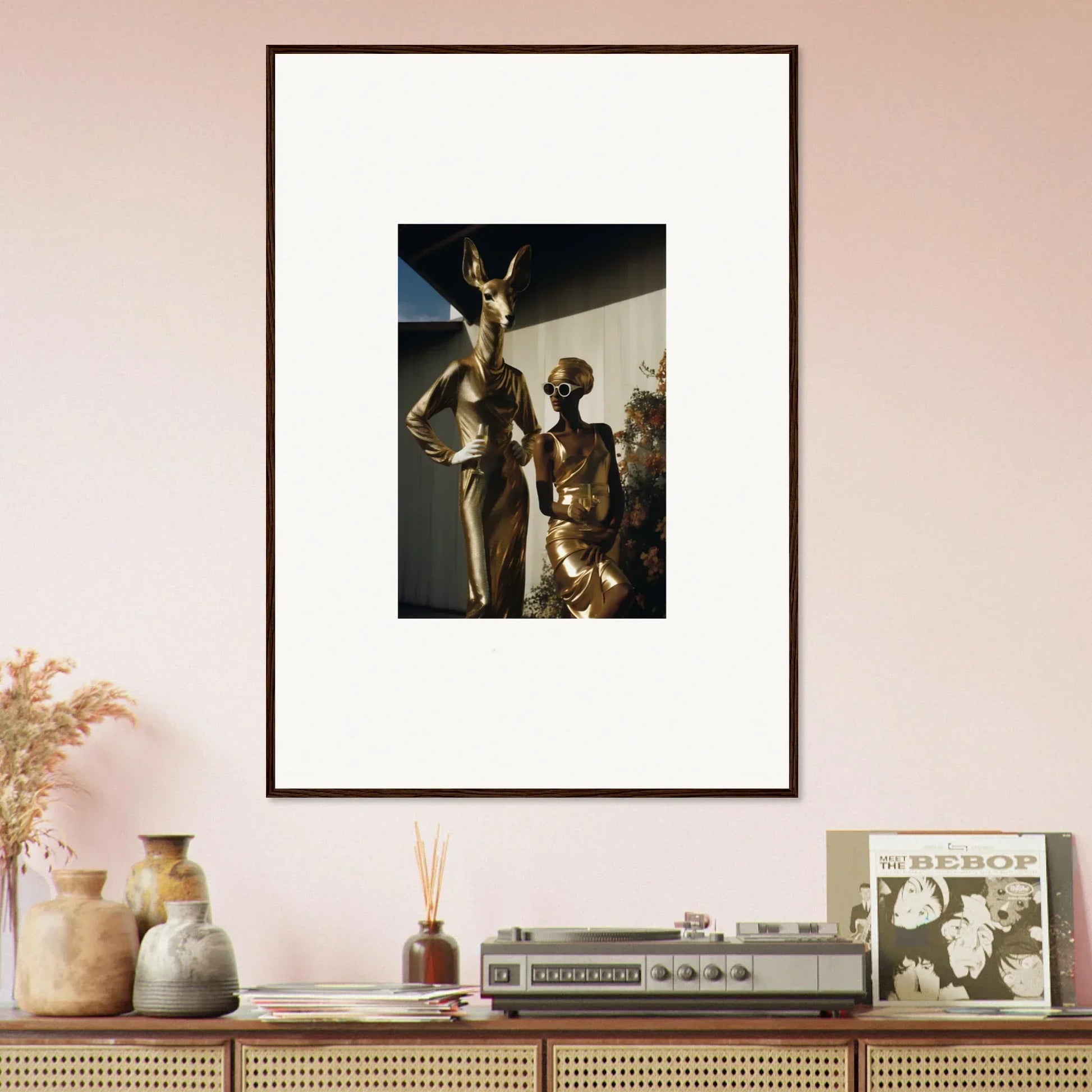 Framed photograph of bronze-like statues depicting human figures in dynamic poses.